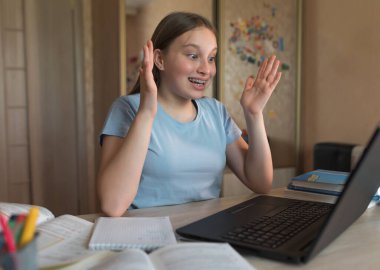 Teenager girl, delighted surprised, emotions of joy, success and surprise, online education at home with laptop. Successful school and college exam, high score and approval. Big win and good luck.