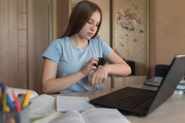 Teen girl, home lessons at a laptop, playing with an animal, rat mouse, video tutoring lessons, home education, preparation for college and school. Video conference on the Internet.