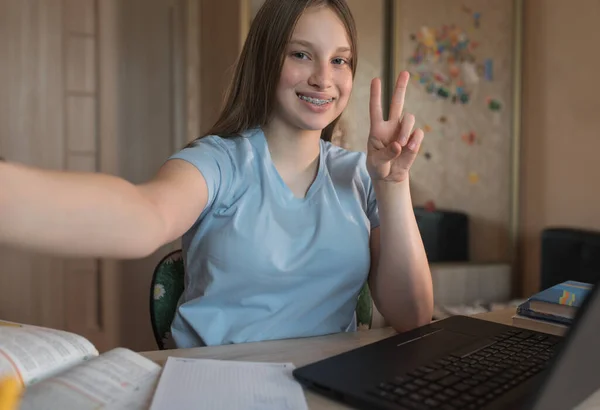 Happy teenager girl smiling on video call phone, taking selfie on smartphone, internet conference, home education and learning to school college. Emotions of happiness braces on teeth. — ストック写真