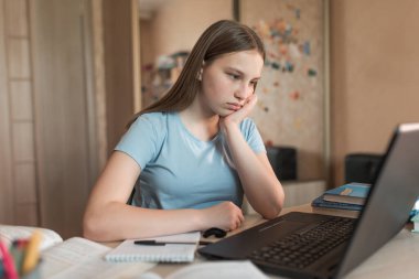 teenager girl is upset sad, tired, problem is not understanding denial, a poor mark in exam, difficult task equalization, electronic education at home using a laptop on Internet. Fatigue after class.
