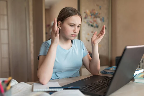 Chica adolescente, molesto sorprendido, problema es no entender la negación, mala nota en el examen, tarea difícil y nivelación, la educación electrónica en el hogar utilizando el ordenador portátil en Internet. Videollamada con un profesor . Imágenes de stock libres de derechos