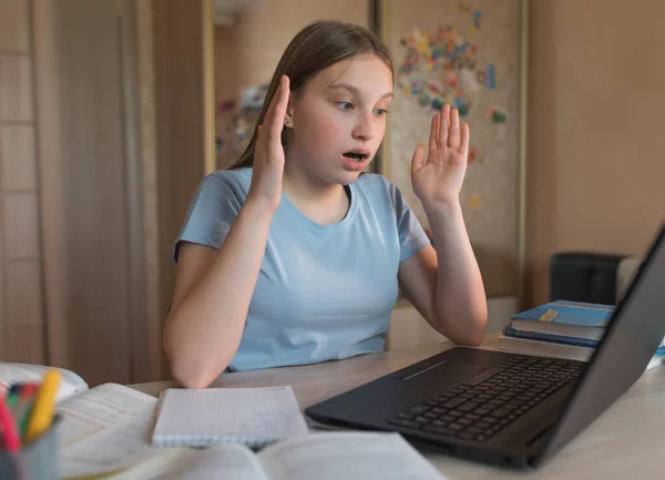 teenager girl, surprised in shock and not understanding, big win, luck success, good exam, a test passed, a virus and a computer error, electronic education at home using a laptop on the Internet.