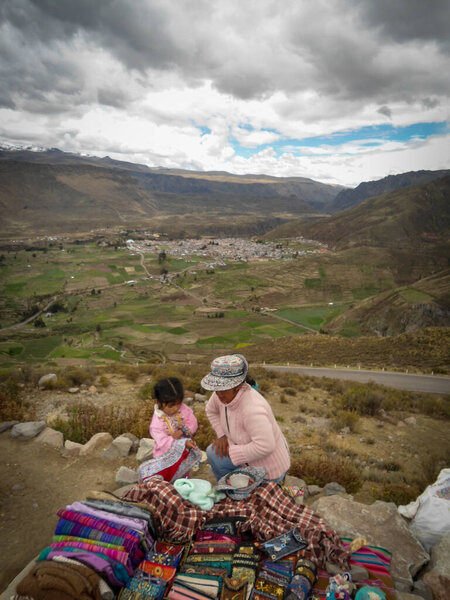 Woman and his child selling souvenir in the Colca Canyon in Peru