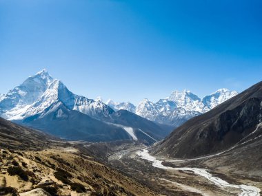 Everest ana kampında yalnız bir yürüyüşçü. Yüksek dağlar, bulutlu bir gün. İnanılmaz bir vadi. Nepal 'deki yüksek dağlar