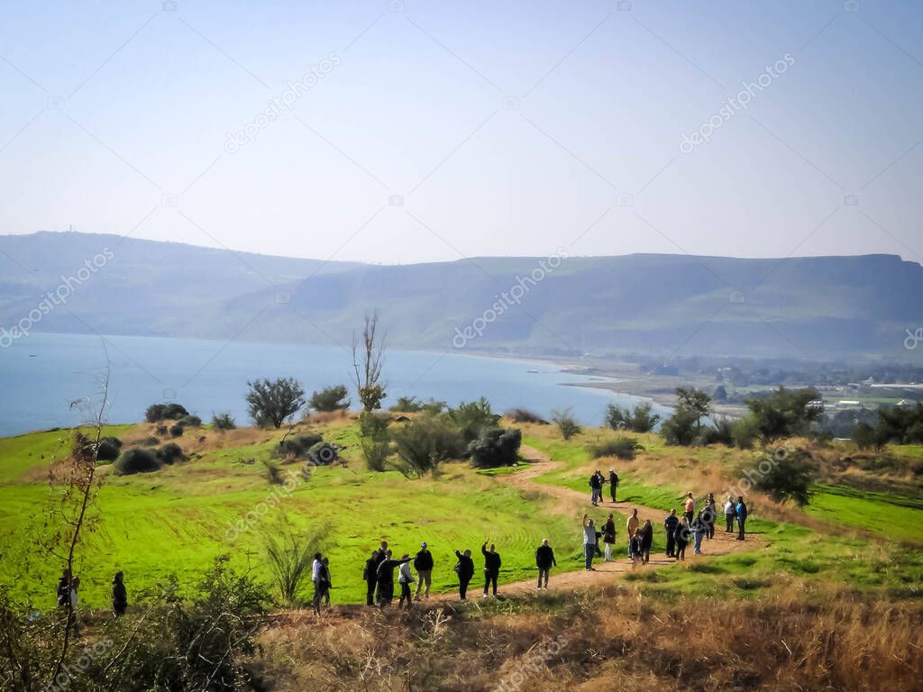 Group of tourists going down to the Sea of Galilee in beautiful landscape in a sunny day