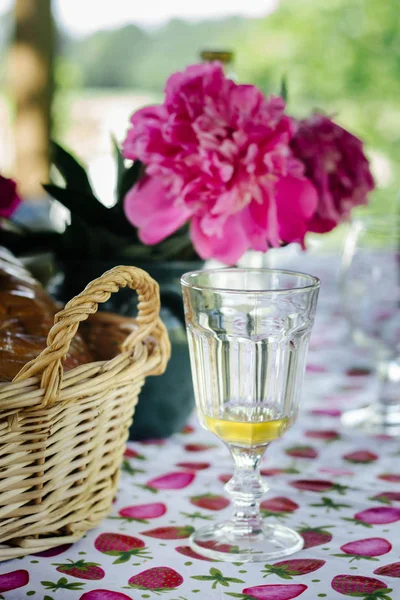 夏季花园派对桌与面包在柳条篮子 美味的柠檬水和粉红色的牡丹 — 图库照片
