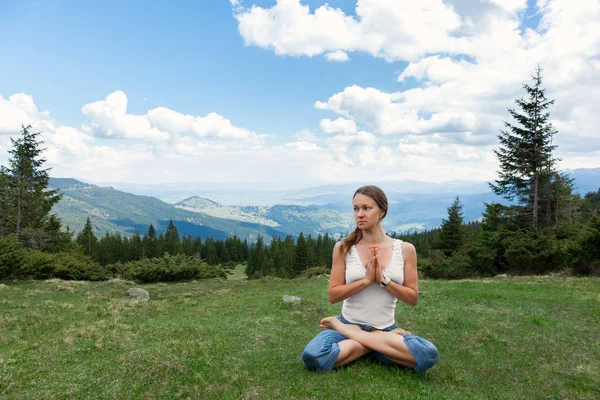 Genç kadın yeşil dağlar, padmasana Yoga pratik 