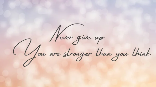 Inspirational quote on a bokeh background with the text Never give up you are stronger than you think. Message or card. Concept of inspiration. Positive phrase. Poster, card, banner design
