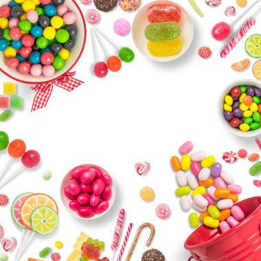 Lolipop ve şeker. Renkli tatlılar, şenlikli dekorasyon. Beyaz arkaplanda renkli şekerler, mesaj veya tebrik kartı için fotokopi alanı olan üst görünüm. Şeker ve tatlı kavramı. Boşluğu kopyala.