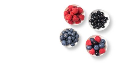 Beyaz arka planda beyaz kaselerde meyve ve fotokopi alanı karışımı. Sulu, taze, organik ve sağlıklı kavramı. Alıcılara lezzetli ve taze böğürtlenlerin üst görünümü.