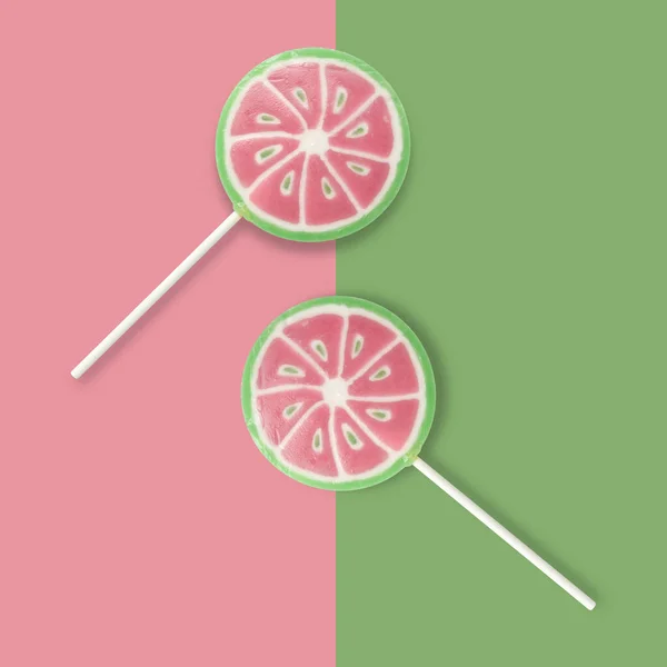 在粉色和绿色背景上的西瓜棒棒糖 横幅和背景色与棒棒糖和复制空间 顶部视图 — 图库照片