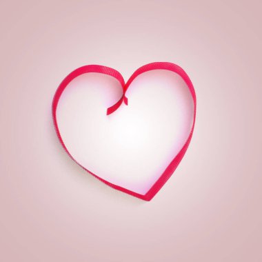 Dekoratif kırmızı fiyonk ve pembe arka planda kalp şeklinde kurdeleler. Tatil, San Valentine dekorasyonu. Hediyeyle ilgili. Kopyalama alanı olan çerçeve.