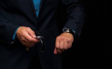 Kol saati koyu mavi ceketli bir iş adamının elinde..