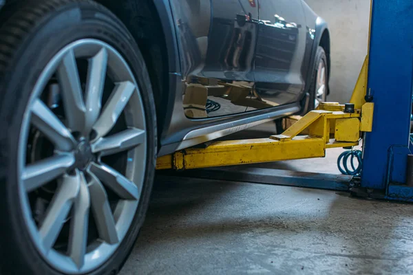 in a car service, the car is located on the wine lift side part of the car and partly wheels