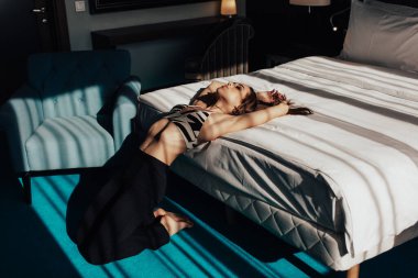 Genç, güzel bir kız, sarışın, parlak mavi gözlü, güzel bir gülüşü ve güzel bir yüzü olan, güneşli sabah ışıklarıyla dolu bir otel odasında..