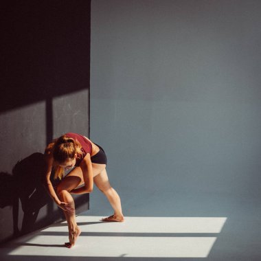 Genç bir kız, bir jimnastikçi, plastik figürlü, stüdyodaki küpleri plastikleştiriyor, pencereden gelen güneş ışığı onun üzerinde parlıyor..