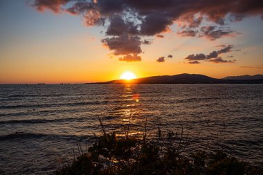 Açık deniz günbatımı, Gelendzhik tatil beldesindeki körfezi ve dağları sorunsuzca terk eder. Renkli yaz manzarası ve Karadeniz kıyısında tatil