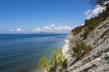Yaz manzarası. Gelendzhik tatil beldesi ve komşu Novorossiysk kenti yakınlarındaki kayaların eteklerindeki pitoresk taştan bir kumsal. Rusya, Karadeniz kıyısı