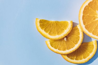 Dilimlenmiş portakal meyvesi, mavi kara zeminde izole edilmiş, pop sanatı rengi konsepti. Mavi arkaplan.