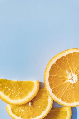 Dilimlenmiş portakal meyvesi, mavi kara zeminde izole edilmiş, pop sanatı rengi konsepti. Mavi arkaplan.