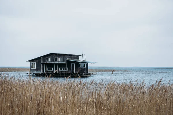 Grande maison en bois au milieu du lac, avec plié tout autour. Journée fumée. — Photo