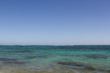 Mavi ve turkuaz deniz güneşli bir günde rüzgara yakalanıyor