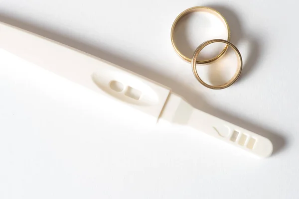 Těhotenský Test Dvě Zlaté Snubní Prsteny — Stock fotografie