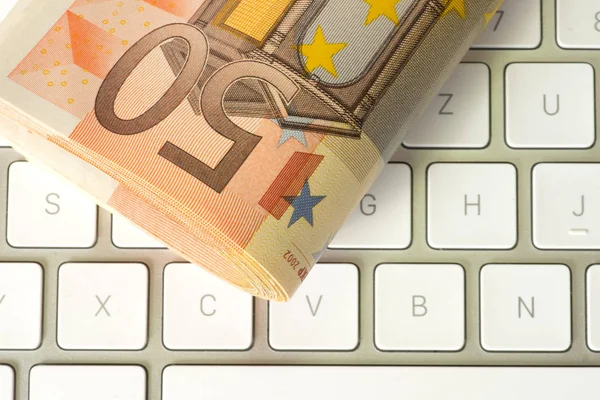 Euro bills and a computer