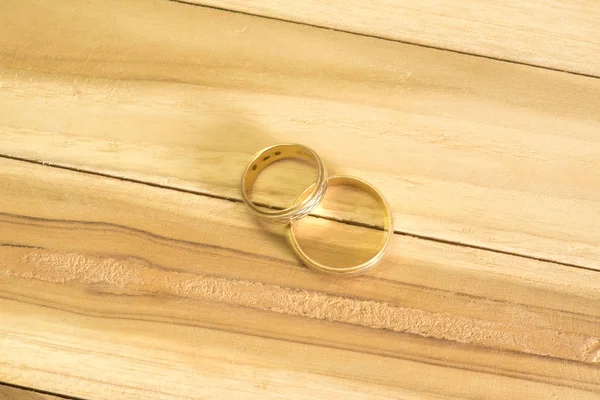Ahşap bir masa üzerinde iki altın alyans
