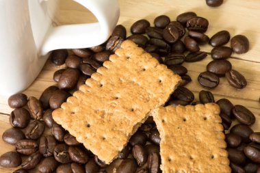 Kahve çekirdekleri, bisküvi ve bir fincan kahve