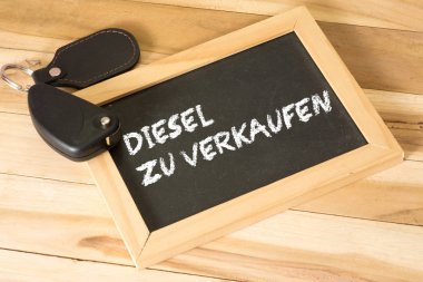 Bir araba anahtarı ve Satılık dizel metinle yazı tahtası