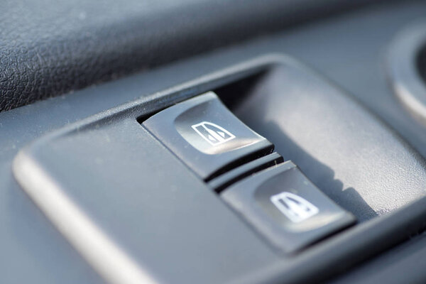 Operating switch for the power windows in a car