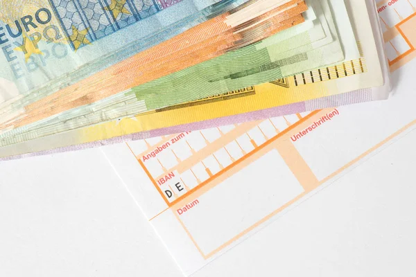Euro banknotes and a form for a bank transfer