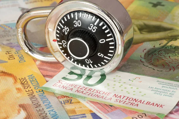 Banknotes Swiss francs and a padlock with number combination