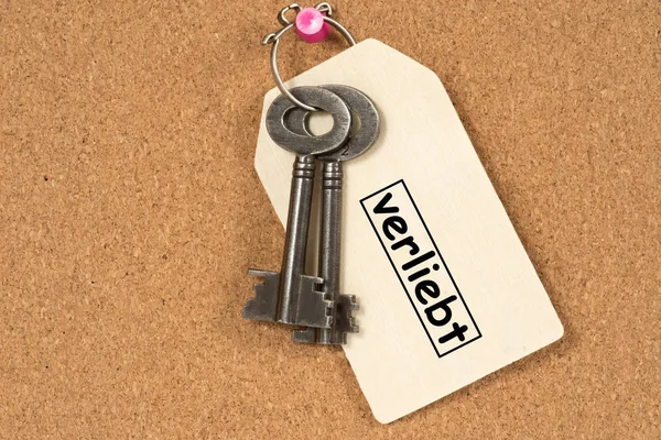一把钥匙和一个带有爱情文字的牌子 — 图库照片