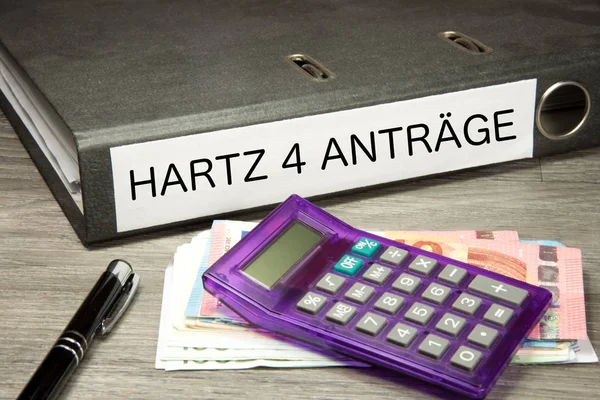 A calculator, euro bills and a folder with Hartz 4 applications