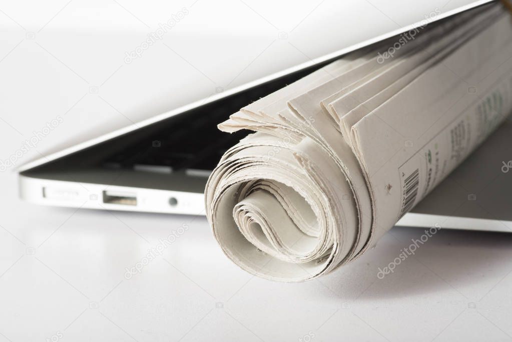 A newspaper and a computer