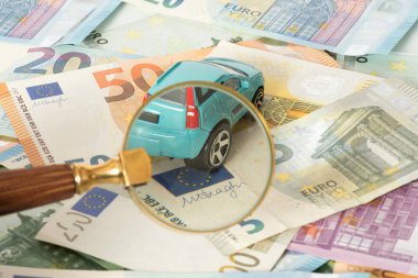 Bir araba, bir büyüteç ve euro faturaları