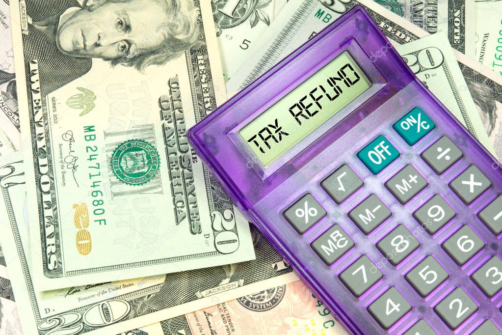 Dollar bills, a calculator and tax refund