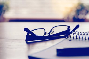 Gönüllülük gözlük ve bir kalem ofiste bir tabloda bir defter,