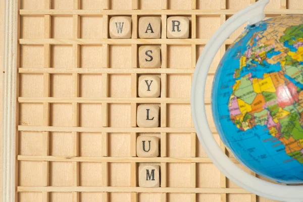 A globe, wooden letters and words War and asylum