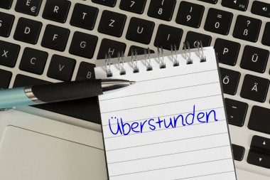 Bir bilgisayar, kalem ve fazla mesai için not etmek