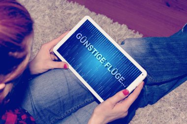 Bir kadın ucuz uçuşlar için Tablet PC'de arıyor