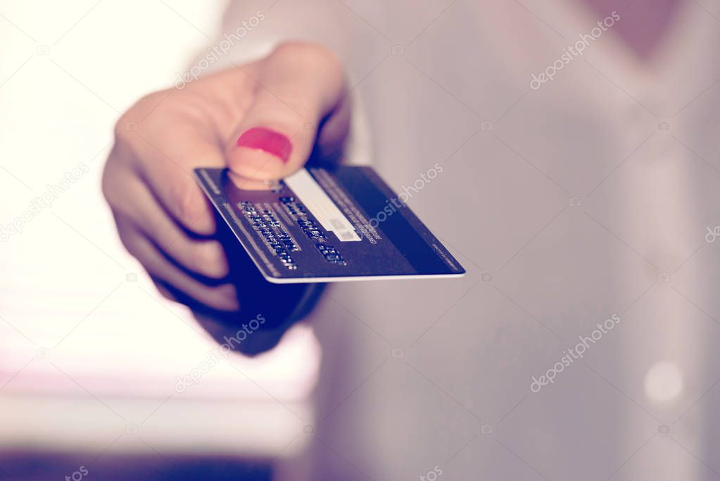 A woman is holding a credit card in her hand