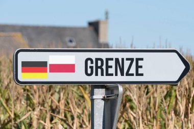 A sign points to the border between Germany and Poland clipart