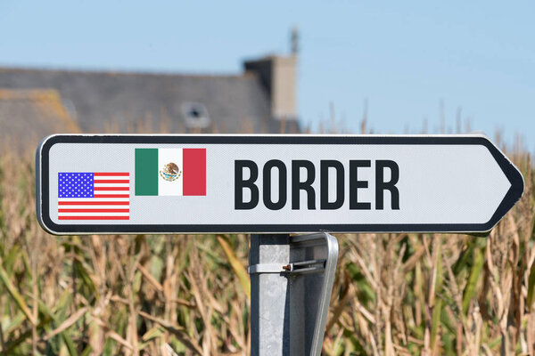 A sign indicates the border between USA and Mexico