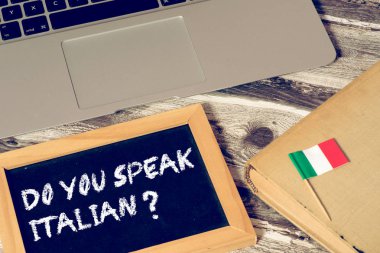 Bir bilgisayar, kitap, İtalya bayrağı ve soru. İtalyanca biliyor musun?