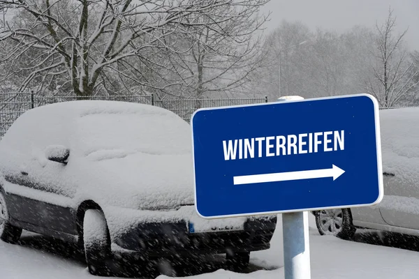 A car, snow, winter and a sign indicating winter tires