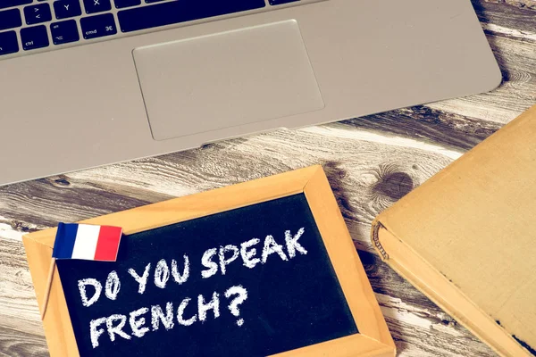 A computer, a book and a question. Do you speak French