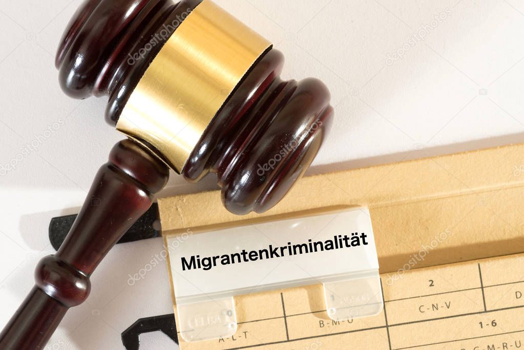 A gavel and a folder with the imprint Migrants crime